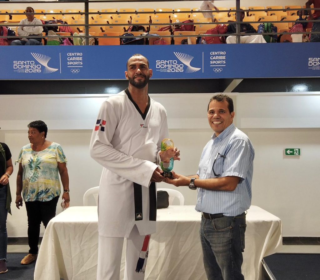 Moisés Hernández, es premiado por el cosecretario de la Federación Dominicana de Taekwondo, José Paulino. (Crédito: Prensa Fedotae)