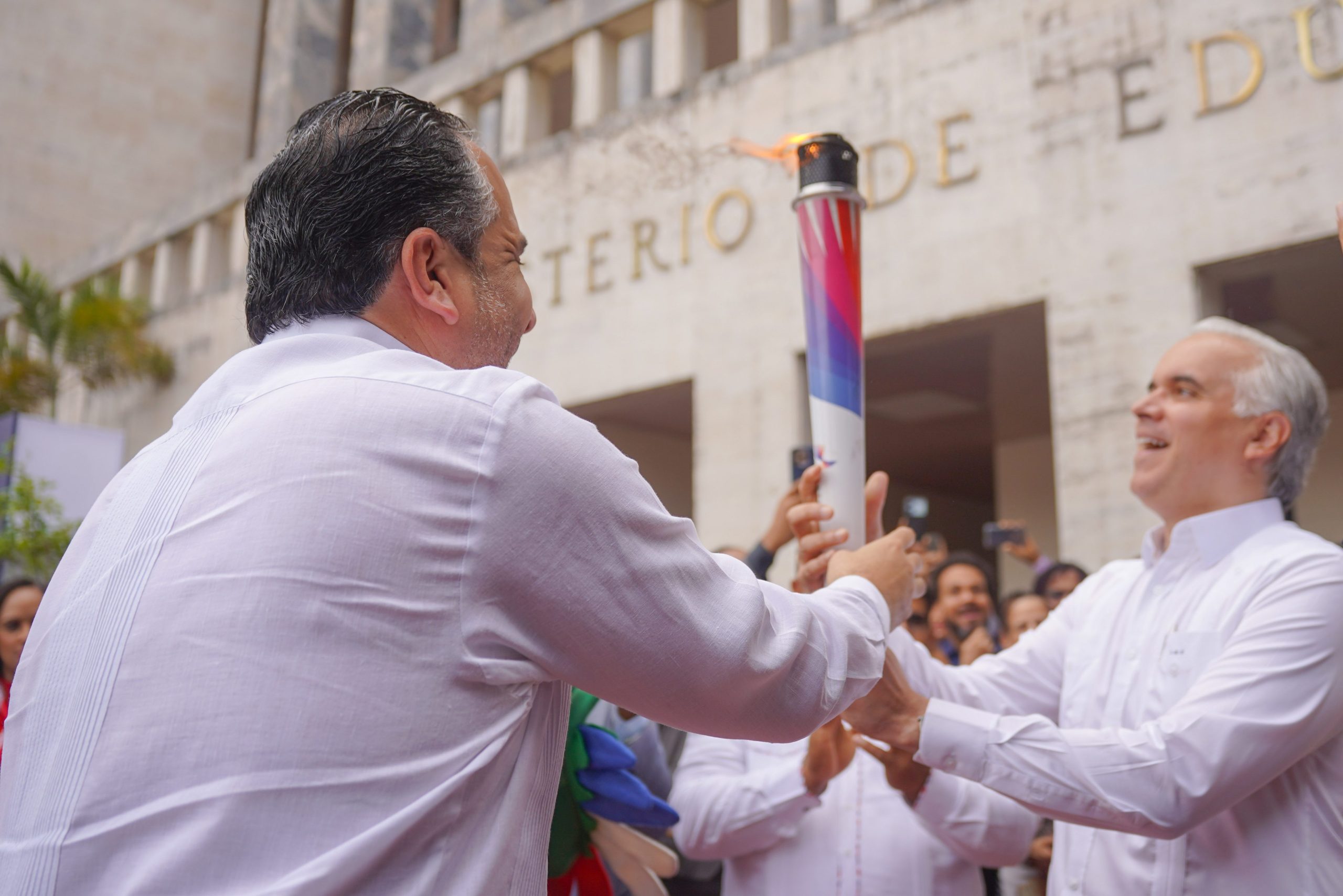 Alberto Rodríguez Mella, director del INEFI, entrega la Antorcha de los Juegos Santo Domingo 2026, al ministro de Educación, Luis Miguel De Camps. (Crédito: Prensa INEFI)
