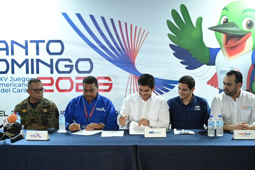 Momento de la firma del convenio entre José Monegro, presidente del Comité Organizador de los Juegos Santo Domingo 2026, y Jhael Isa, vicepresidente ejecutivo de la Empresa Metropolitana de Transporte (EMT). (Crédito: Prensa SDQ2026)